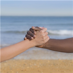 weiße Hand greift dunkle Hand Weite Hand greift dunkle Hand