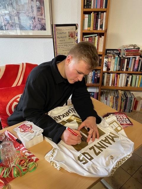 Mann unterschreibt Trikot