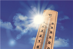 Sommerhitze Im Vordergrund ist ein Thermometer zu sehen. Die Temperaturen steigen über 30 Grad Celsius. Im Hintergrund scheint die Sonne. Der Himmel leuchtet blau.