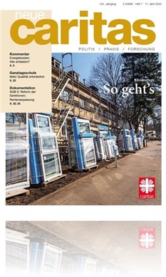 Das Bild zeigt die Titelseite der Zeitschrift neue caritas - Ausgabe 07 / 2022 . Man sieht darauf bereitgestellte neue Fenster zum Einbau in einen Wohnblock.