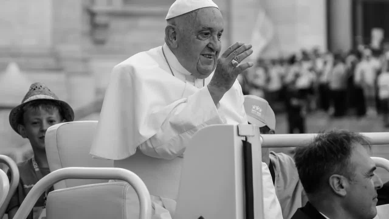 Papst Franziskus winkt dem Publikum aus einem Fahrzeug heraus