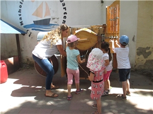 Eine Frau steht mit vier Kindergartenkindern an einem Spielgerät.