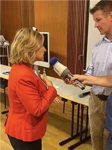 Klimaministerin Katrin Eder im Gespräch mit zwei Journalisten