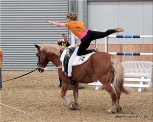 Mädchen turnt auf Pferd