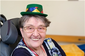 Karneval Eine ältere Frau hat ein Karnevalshütchen auf und lacht fröhlich