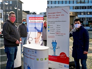 Sven Roder (2. von li.) von der Verbraucherzentrale steht mit drei Caritas-Stromsparhelfern mit Werbebannern in der Bochumer Innenstadt