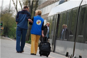 Eine Mitarbeiter der Bahnhofsmission Bochum führt einen Mann zum Zug