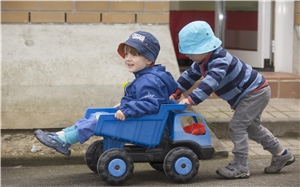 Rafael - Kleinkinder mit Sonnenhut Zwei Kleinkinder mit Sonnenhut spielen draußen mit einem Spielzeugauto