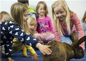 St. Benedikt - Kinder mit Hase Mehrere Kinder streicheln einen Hasen
