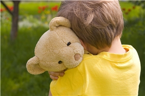 Ein Kind hält einen Teddybären im Arm