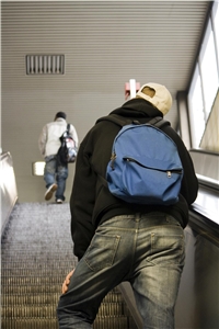 Ein Jugendlicher fährt auf einer Rolltreppe nach oben