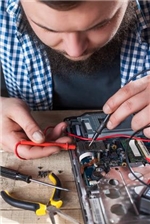 Repair-Cafe Ein junger Mann schraubt an einem Elektro-Gerät