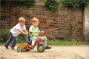Spielende Kinder mit Dreirad