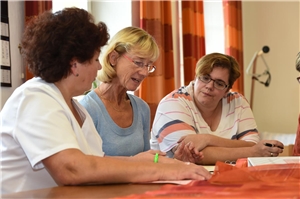 Schulung für Angehörige drei Personen am Tisch im Gespräch