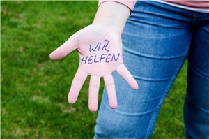 Eine Hand mit dem Schriftzug 'wir helfen'