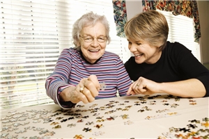 Zwei Frauen setzen ein Puzzlespiel zusammen