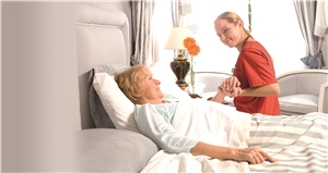 Eine Pflegerin am Bett einer Seniorin