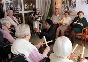 Die Senioren sitzen im Kreis und musizieren mit Orffschen Instrumenten