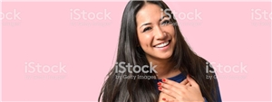Frau mit Händen am Herzen rosa Hintergrund