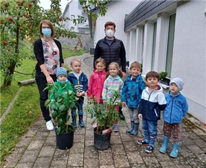 Kinder und ein Gärtner pflanzen im Caritas-Kindergarten St. Andreas in Brilon Blumen, Kräuter und Obst. 