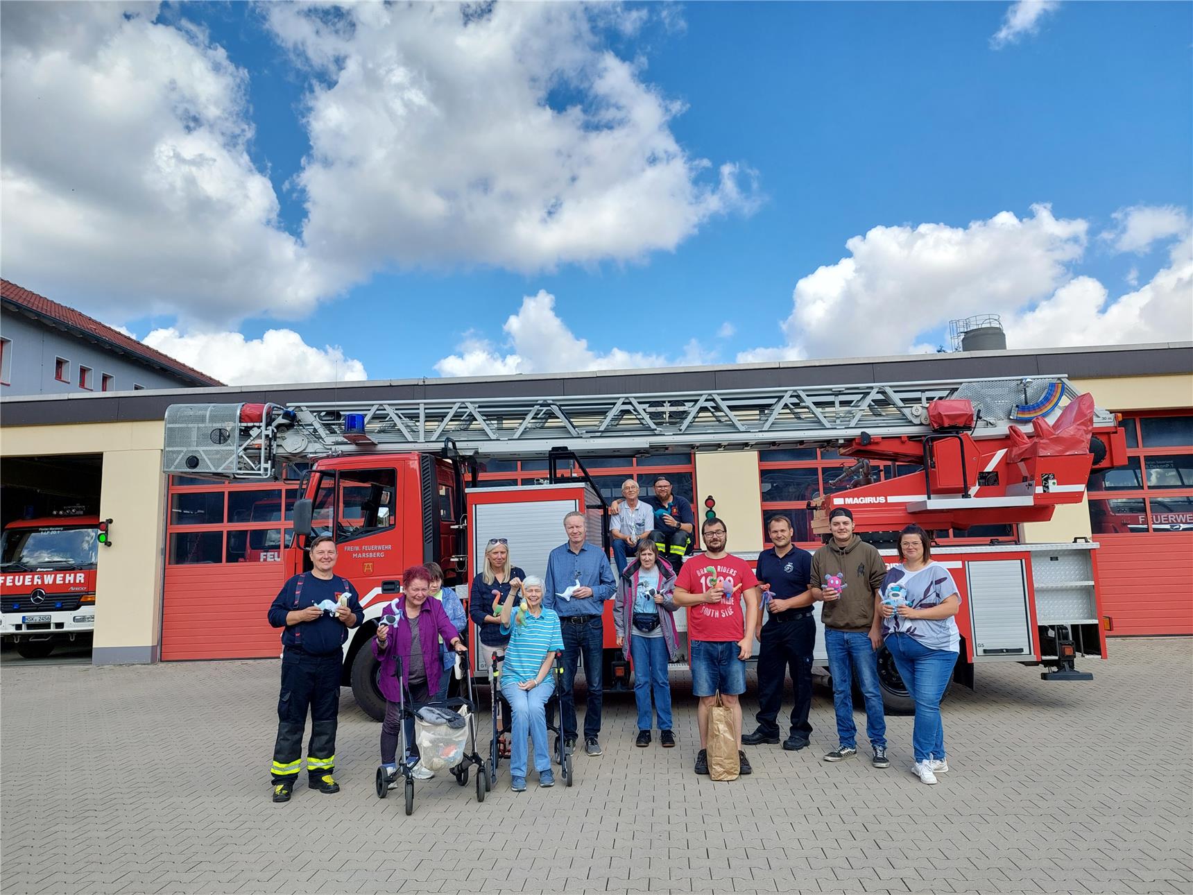Caritas Team übergibt Stofftiere an Feuerwehrleute in Marsberg