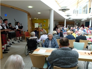 Dudelsackspieler und Trommler unterhalten Gäste im Aufenthaltsraum vom Seniorenhaus Sankt Franziskus