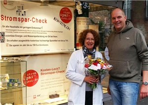Mit einem Blumenstrauß bedankte sich der Projektleiter Christian Kurz vom Stromspar-Check bei der Inhaberin der Wolfsberg Apotheke in Lüdinghausen Claudia Graute für Ihre Unterstützung des Projektes.