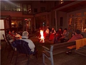 Silvesternacht 2020 - Bewohner*innen sitzen gemütlich um das wärmende Feuer im Hof