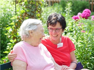 Mitarbeiterin Frau Schwarz und eine Bewohnerin des Altenpflegezentrums im Garten