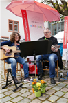 1 Frau und 1 Mann spielen Gitarre auf dem Markt