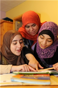 Hilfe für Migrantinnen und Migranten Zwei muslimische Mädchen bei der Hausaufgabenbetreuung