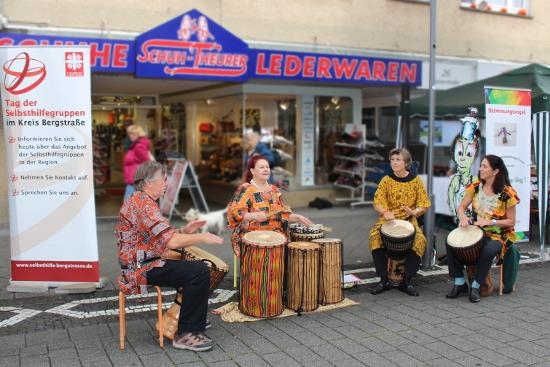 Drei Frauen und ein Mann an Trommeln nach Art der westafrikanischen Djembes