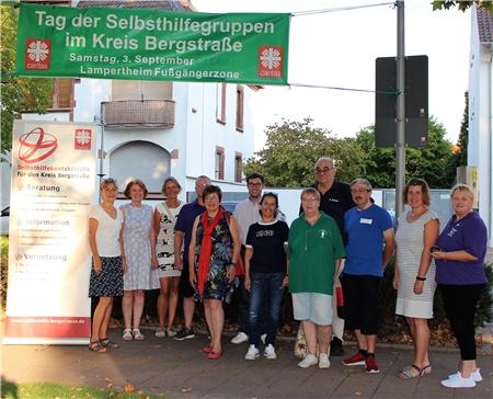 Gruppe von Menschen vor dem Plakat zum Selbsthilfetag 2022 in Lampertheim