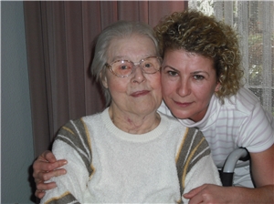 Eine ältere Dame wird von einer Pflegekraft umarmt