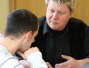 Allgemeine Lebensberatung Junger Mann im Beratungsgespräch mit einem Mitarbeiter