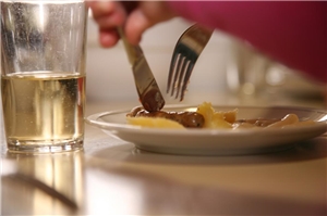 Essen auf Rädern Ein Teller mit Kartoffelbrei und Würstchen und ein Glas Wasser