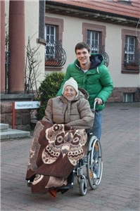 engagierter Freiwilliger mit älterer Frau im Rollstuhl