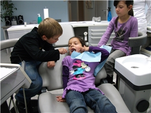Drei Kinder im Behandlungszimmer einer Zahnarztpraxis
