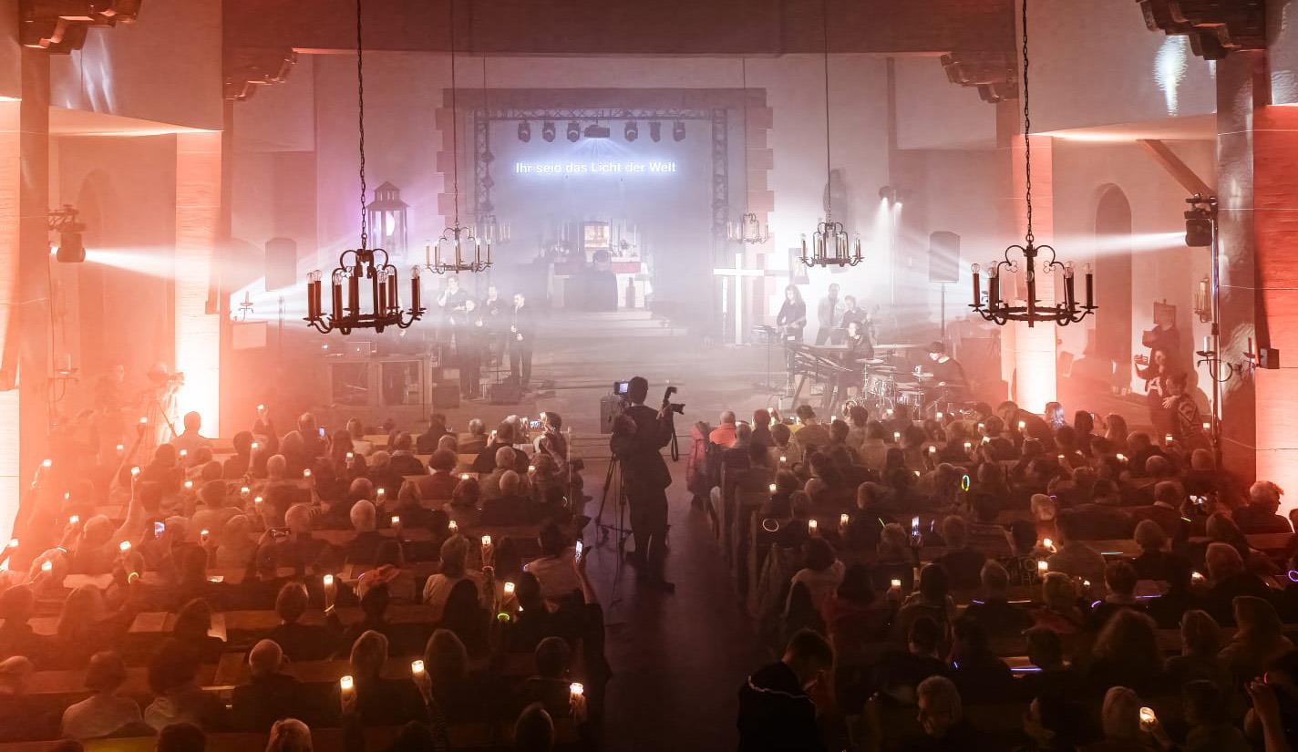 Junge Menschen inszenieren eine spirituelle Lichtshow.