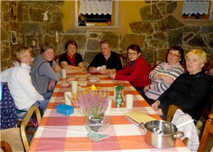 Mehrere Frauen sitzen am Abend an einem Tisch