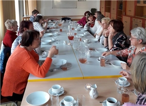 Frauen sitzen an einem gedeckten Tisch und essen