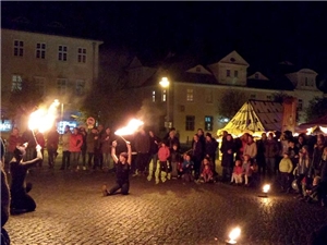 Straßenkünstler zeigen einer Gruppe von Menschen eine Feuershow