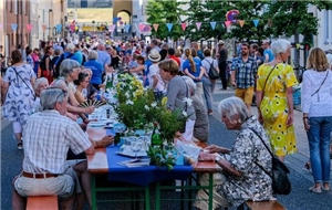 Menschen am gedeckten Tisch bei einem Straßenfest