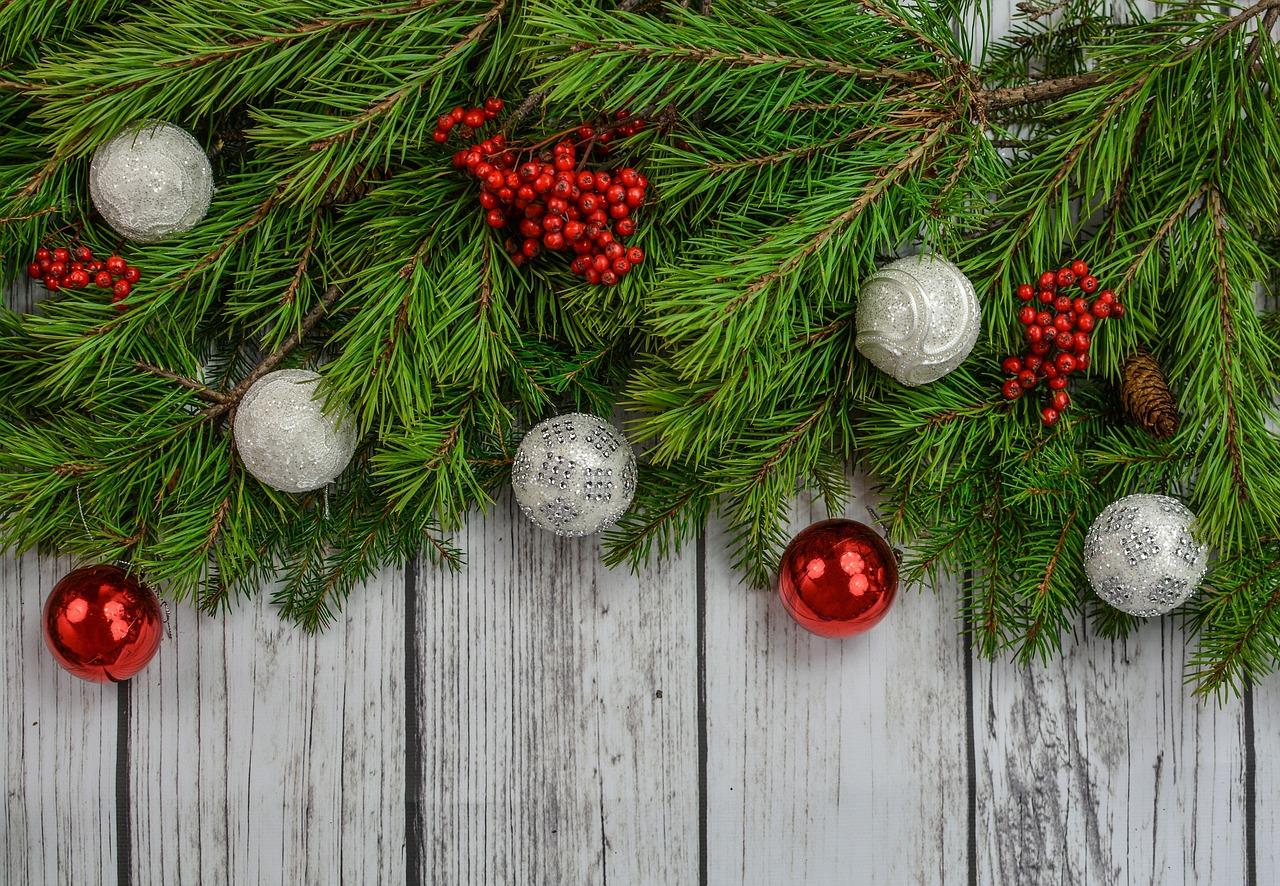 Weihnachtliche Deko mit Tannengrün, roten und weißen Weihnachtskugeln