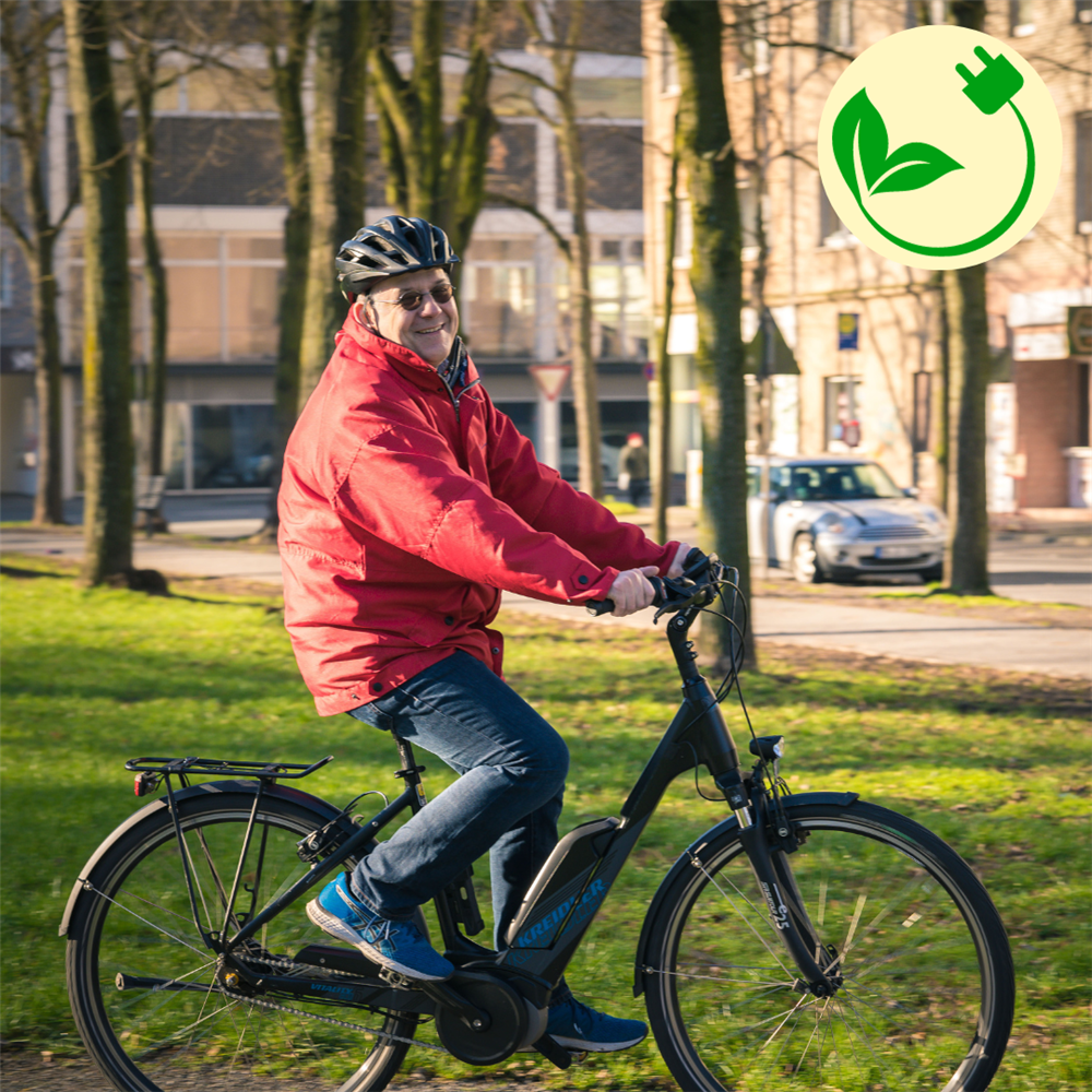 Andreas sitzt auf seinem E-Bike und lächelt in die Kamera