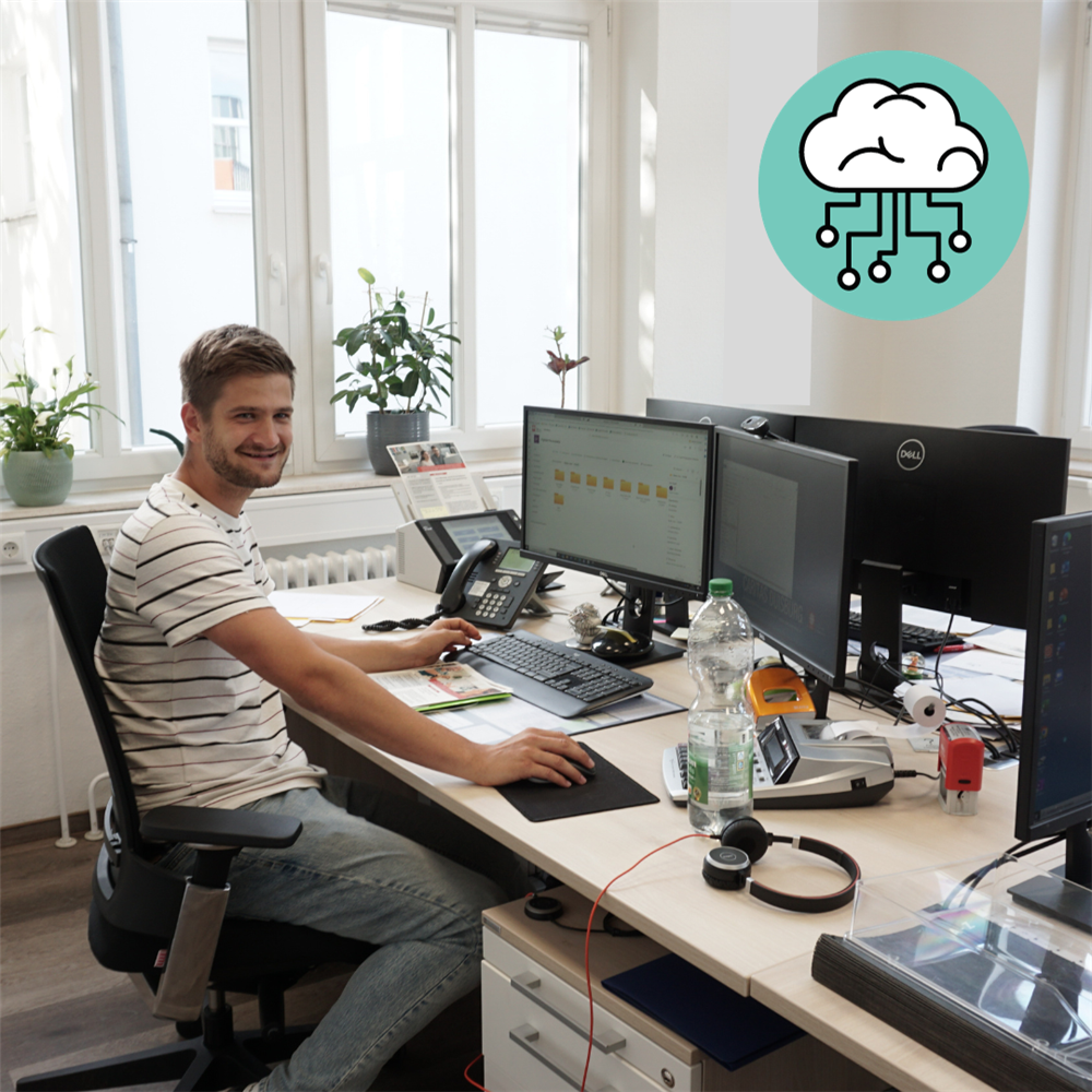 Mitarbeiter sitzt am Schreibtisch vorm PC mit geöffneter digitaler Personalakte