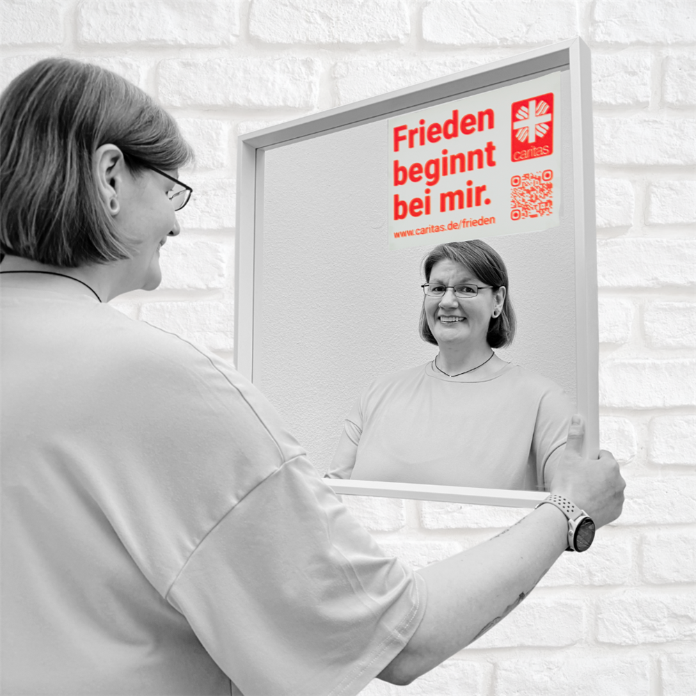 Vanessa steht vorm Spiegel mit aufgeklebtem Motto und lächelt