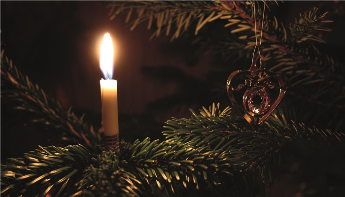 Kerze und Schmuck auf einem Weihnachtsbaum