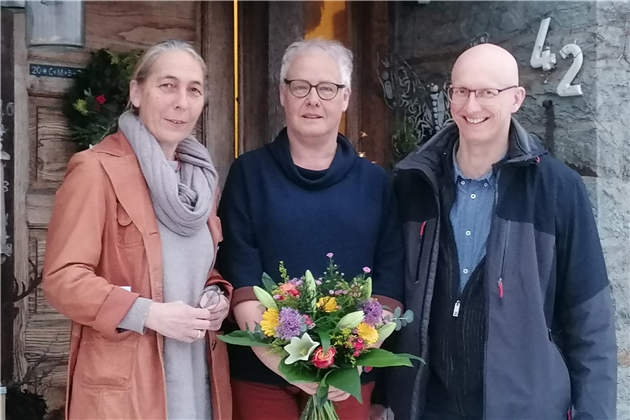 Eva Lindt (l.), Alice Klein (M.) und Norbert Telöken (r.) stehen vor einem Haus, Alice Klein hält einen Blumenstrauß in der Hand