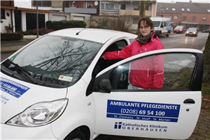 Patricia Röhl vor dem Auto der ambulanten Pflegedienste 
